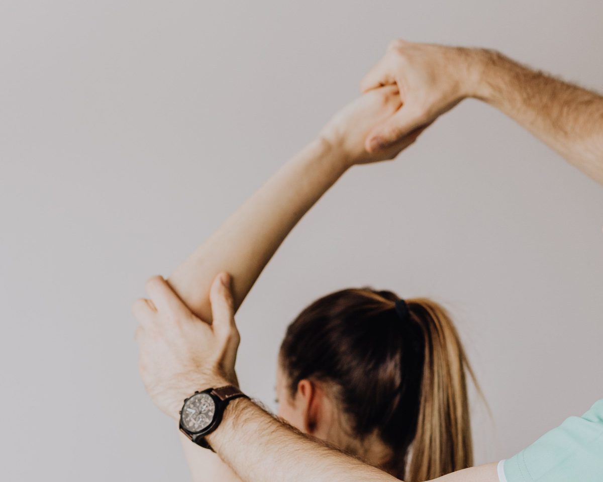 Physiotherapist performing an assisted overhead arm and shoulder stretch on a patient at FixUrMotion in Beirut, Lebanon